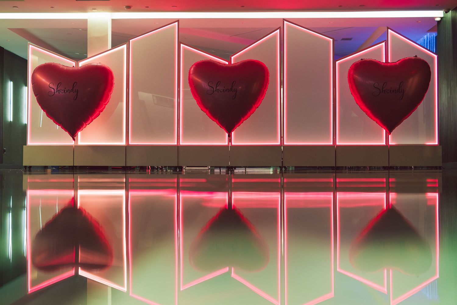 Modern interior design featuring red neon heart lights against a minimalist wall.