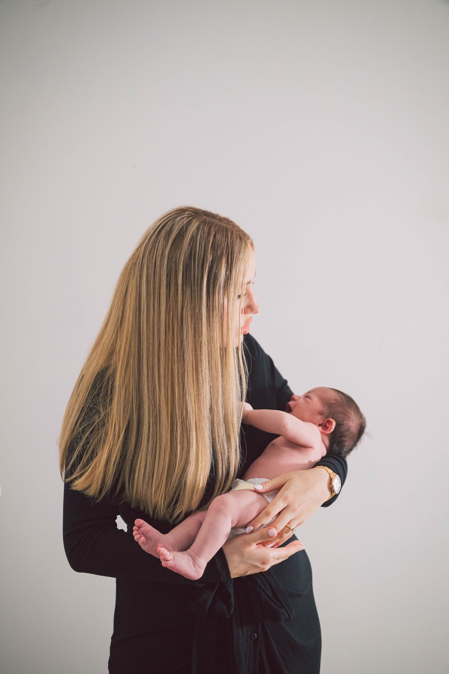 A series of intimate portrait shots showing gentle embraces against a neutral background.