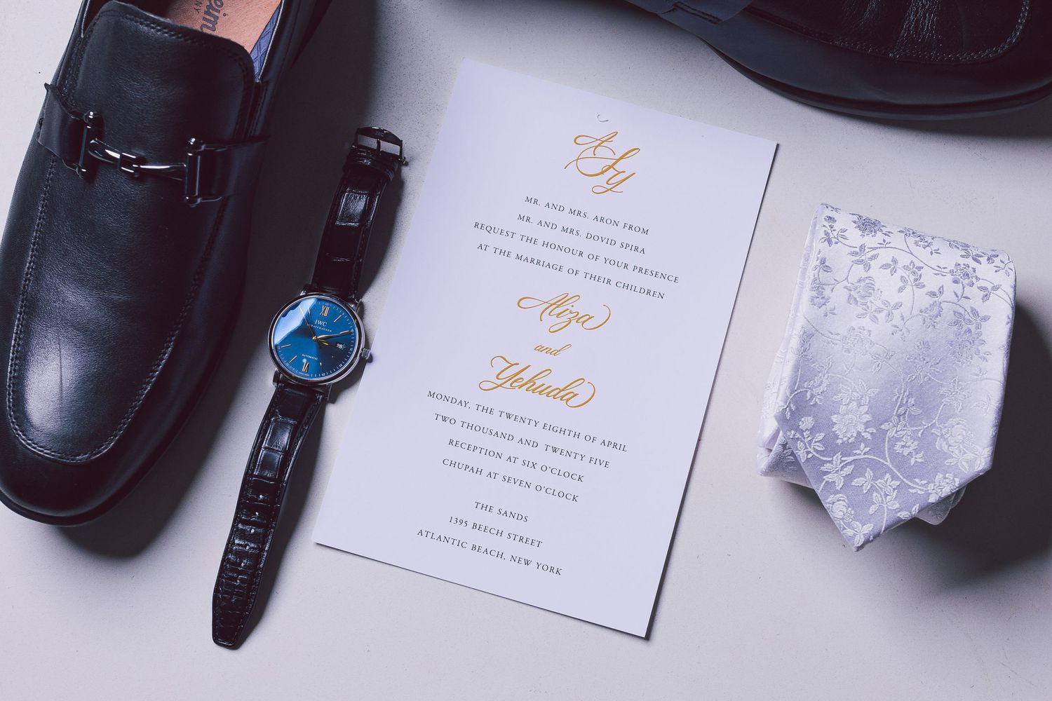 Wedding stationery details with leather accessories and crystal decorative elements.