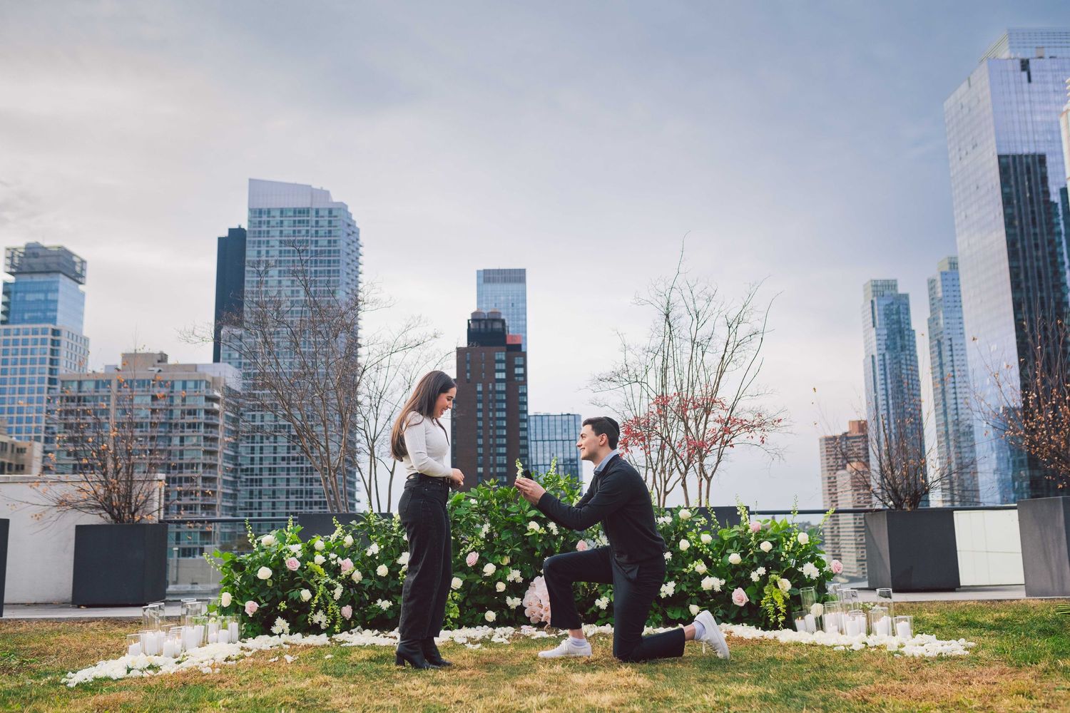 A proposal moment with white floral arrangements .