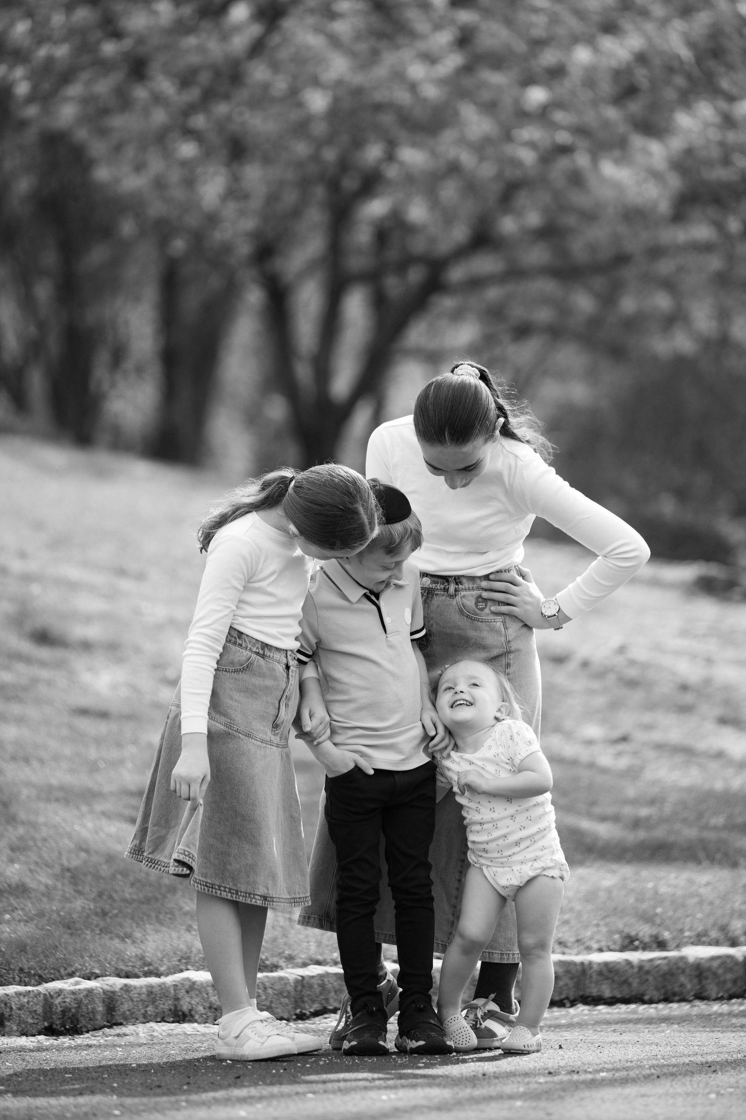 Black and white photo of toddlers exploring together on a curved path outdoors.