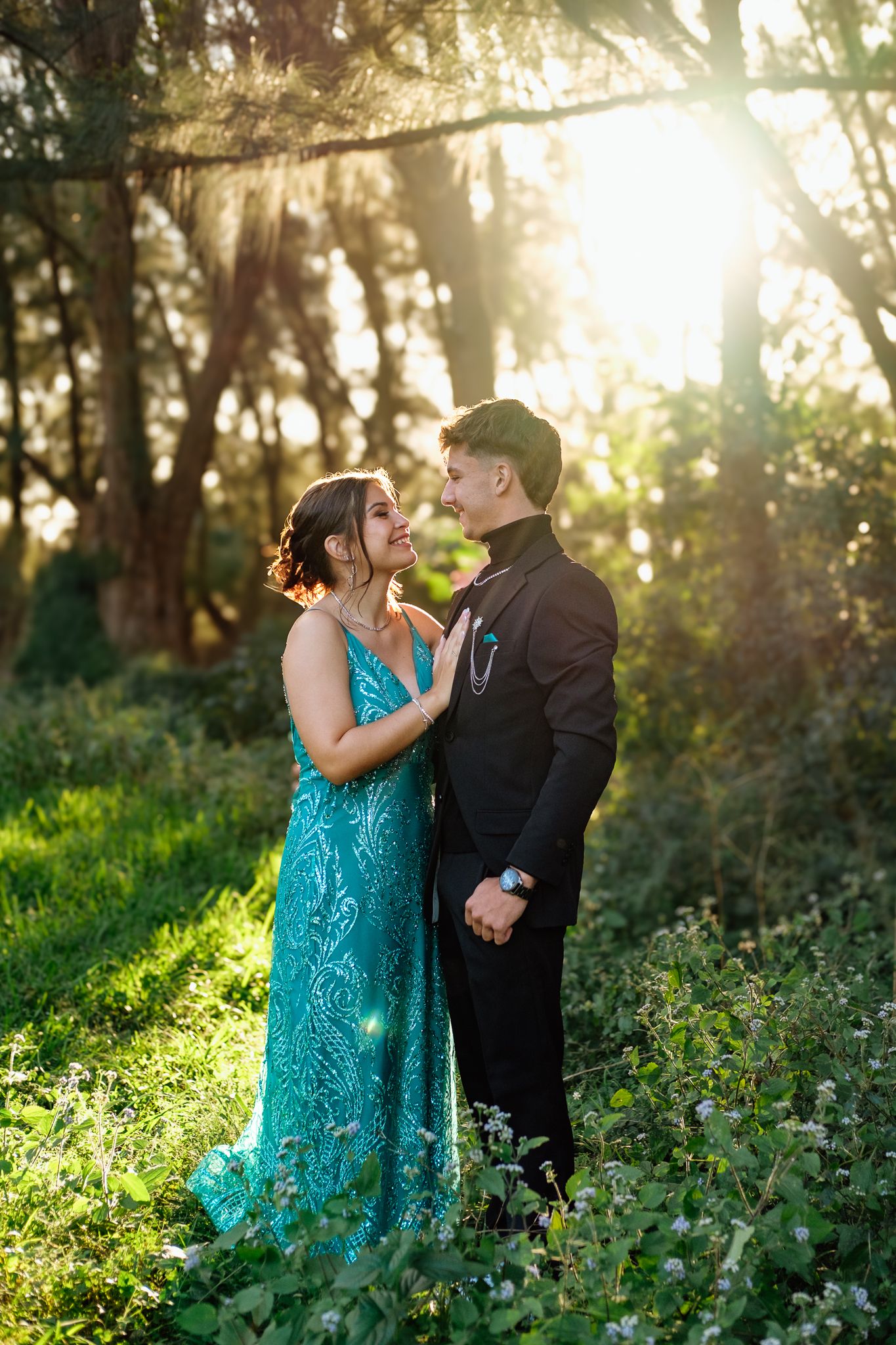 Matric farewell couple photographed in a forest with warm golden sunlight