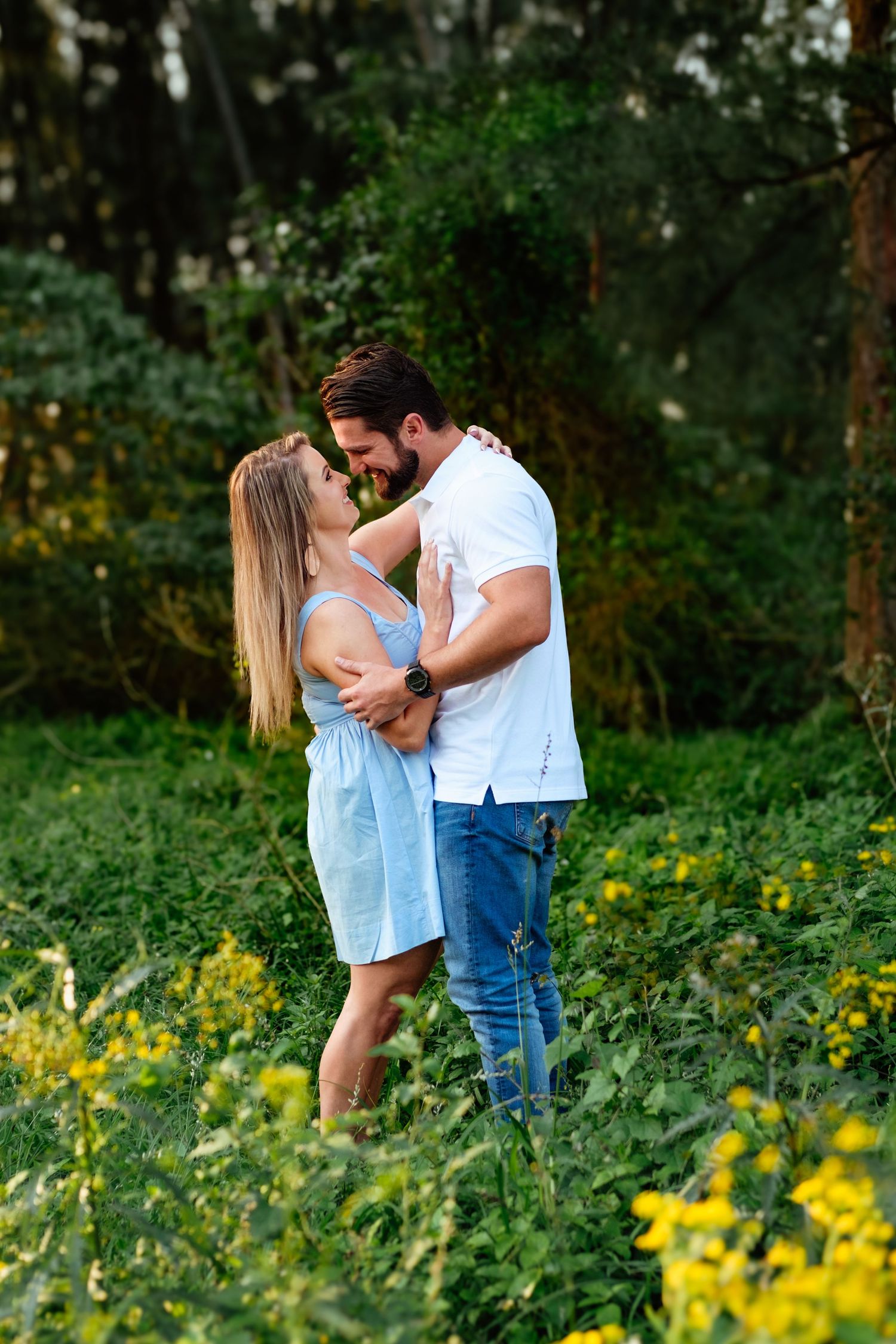 Couple portrait session in a forest surrounded by yellow wildflowers