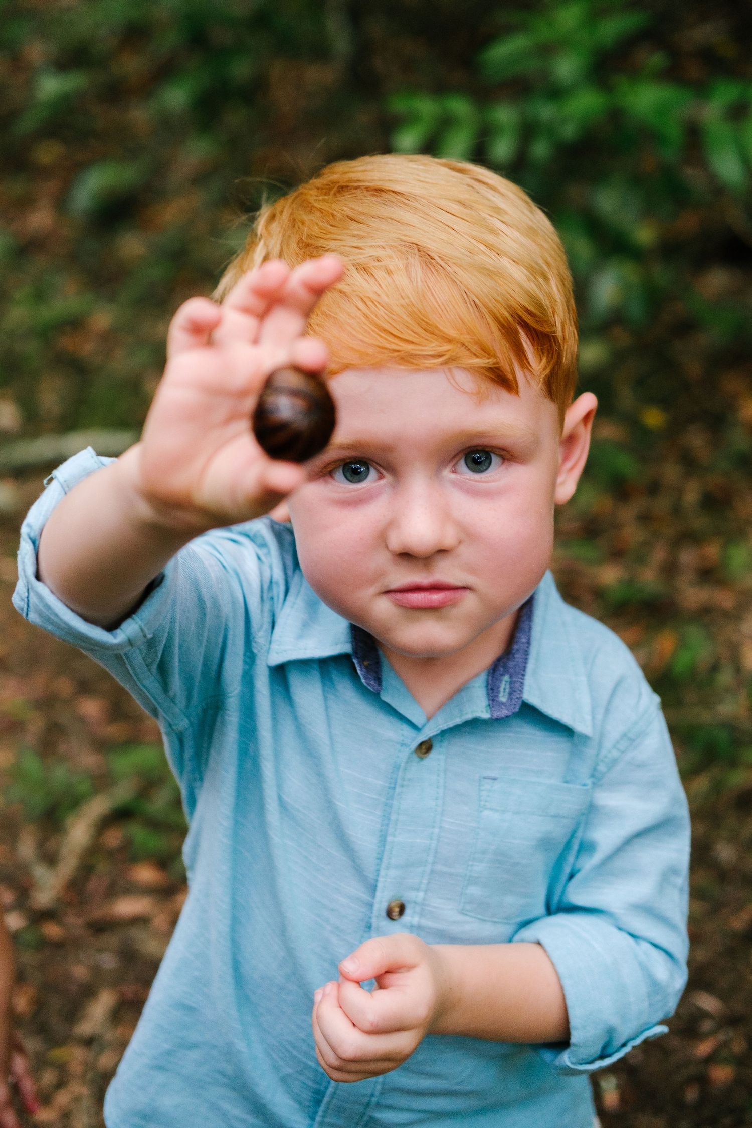 Young boy in a forest showing an armadillo insect