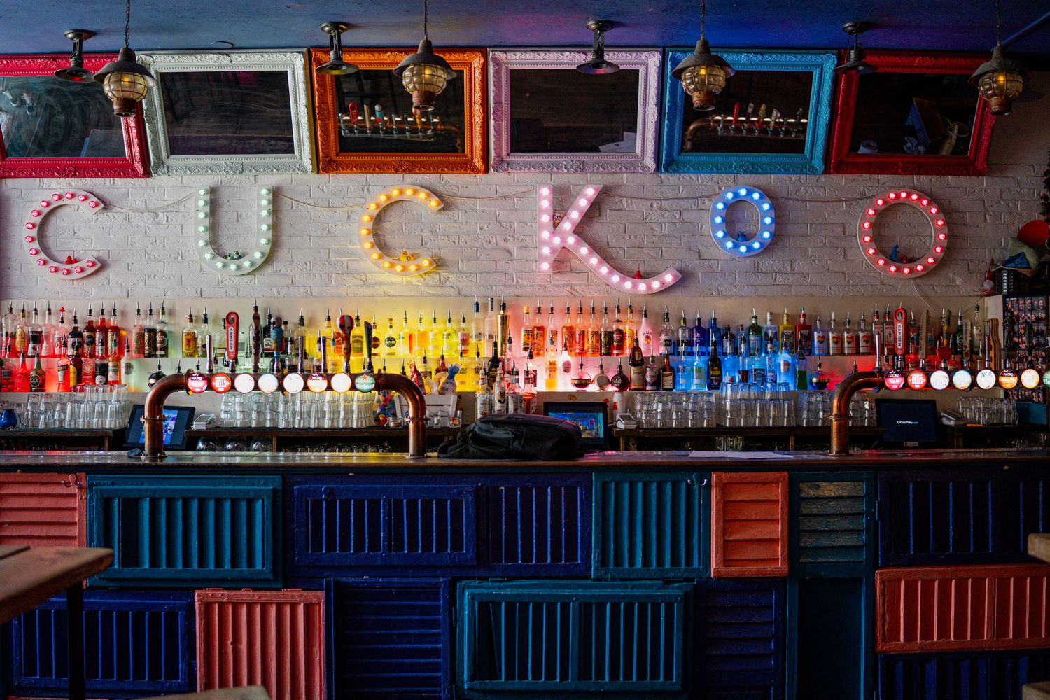Carnival cuckoo games with neon lights and colorful prizes displayed at a fairground arcade.