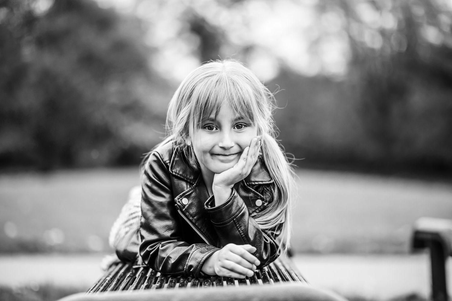 Black and white portrait of someone resting on outdoor furniture.