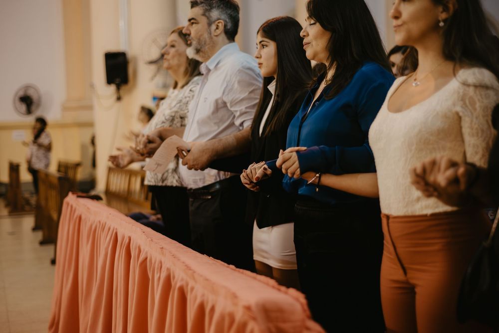 Group of people standing in a row at a church altar during a religious ceremony.