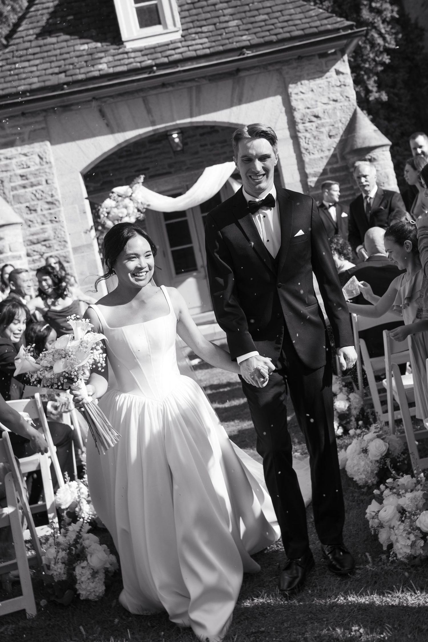 A sequence of black and white photos showing joyful moments at an outdoor wedding celebration with guests and a bride.