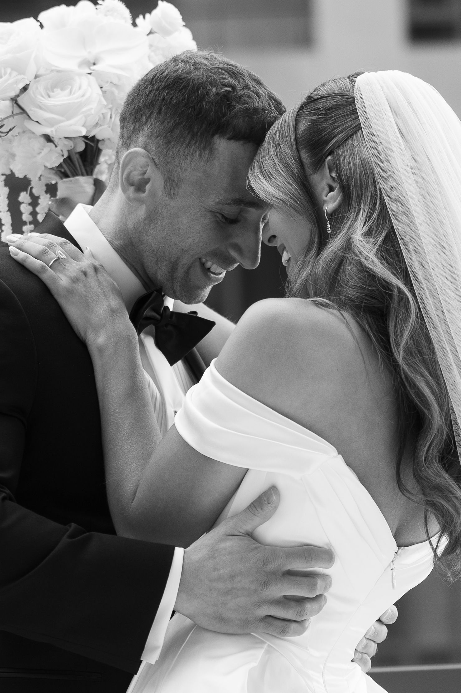 A romantic black and white photo series of newlyweds sharing intimate kisses at their wedding ceremony.