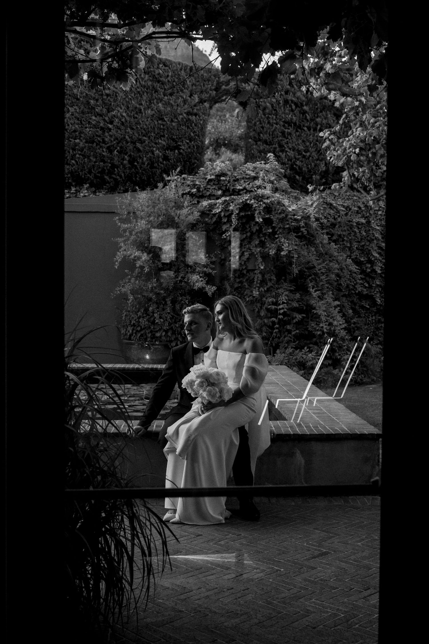 Black and white image of wedding couple sharing quiet moment on outdoor patio. - JCclick Wedding photo & Film - Best Cape Town Photographer.