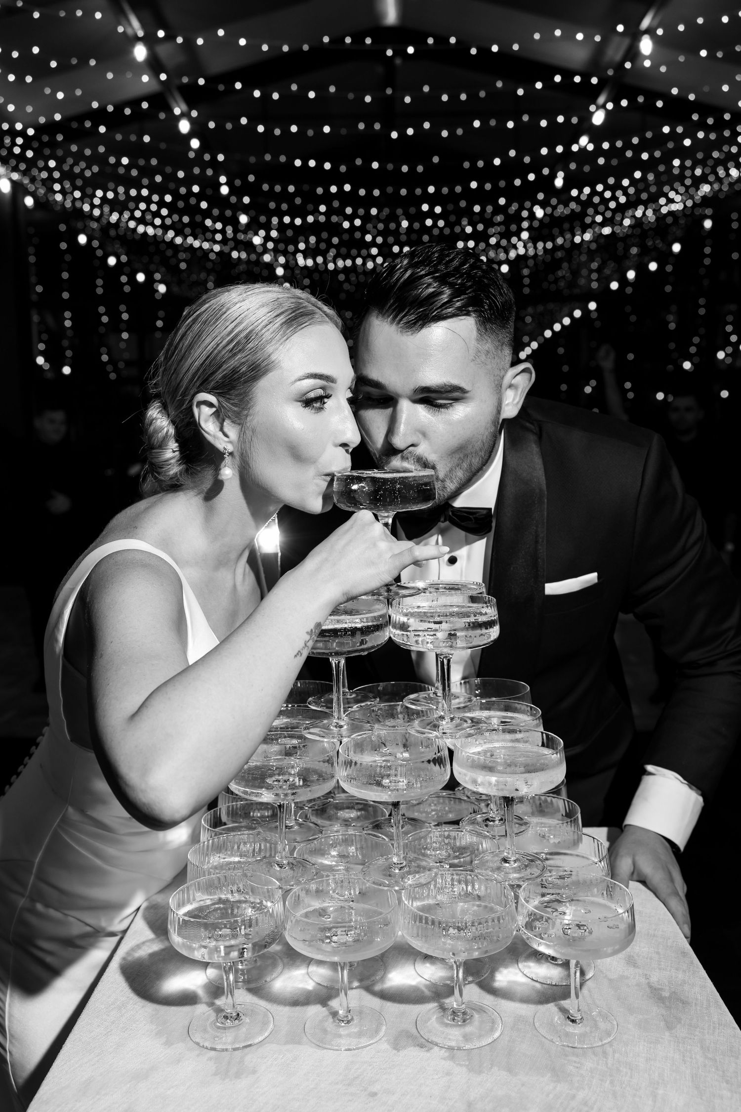 Couple - champagne tower under twinkling lights. - JCclick Wedding photo & Film - Best Cape Town Photographer.