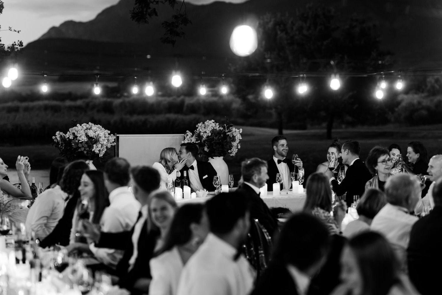 Evening wedding reception with string lights creating a magical atmosphere. - JCclick Wedding photo & Film - Best Cape Town Photographer.