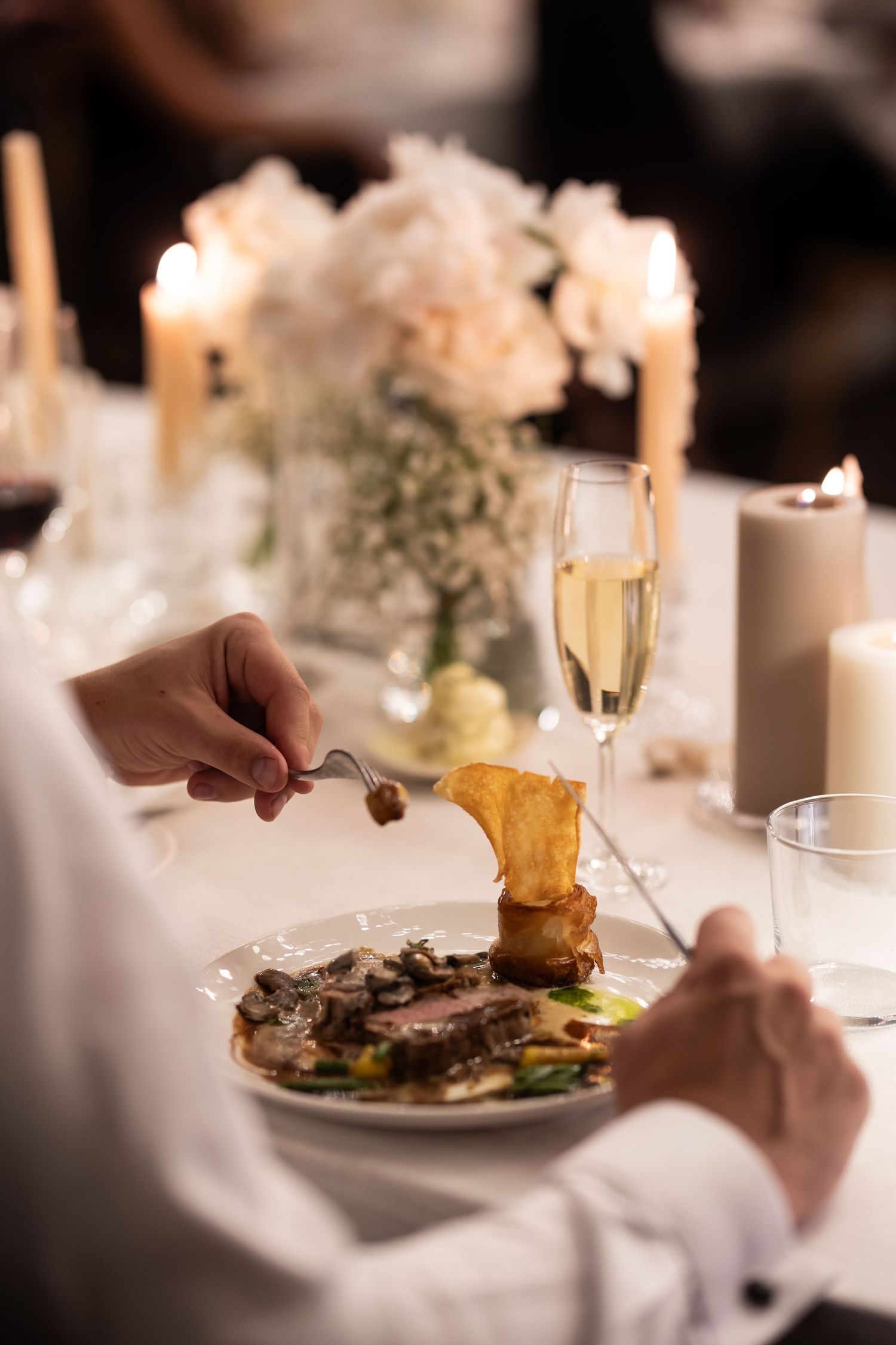 Fine dining table setting with plates and candles in soft focus. - JCclick Wedding photo & Film - Best Cape Town Photographer.