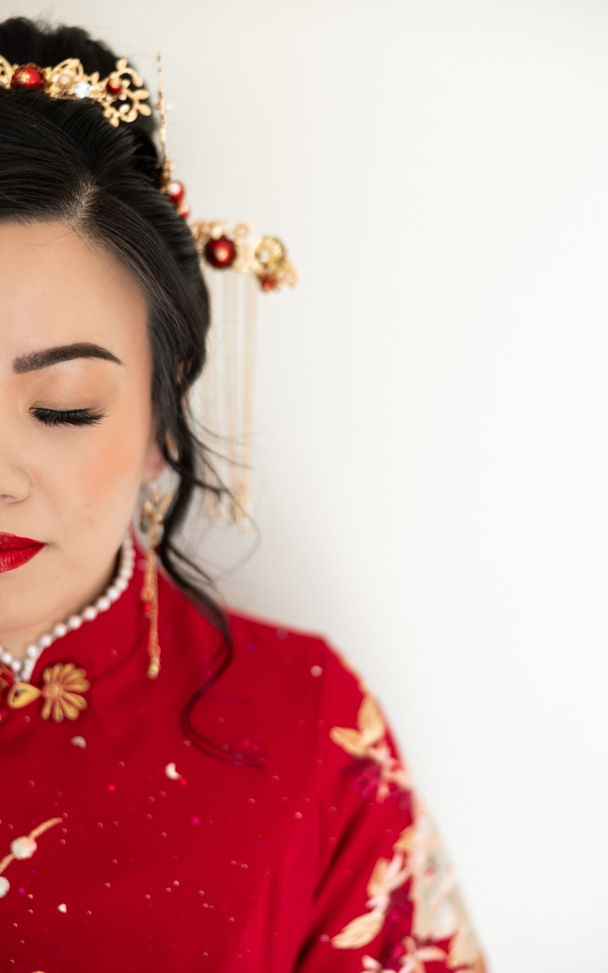 Traditional Asian bridal portrait featuring red qipao and ornate gold hair accessories. - JCclick Wedding photo & Film - Best Cape Town Phot