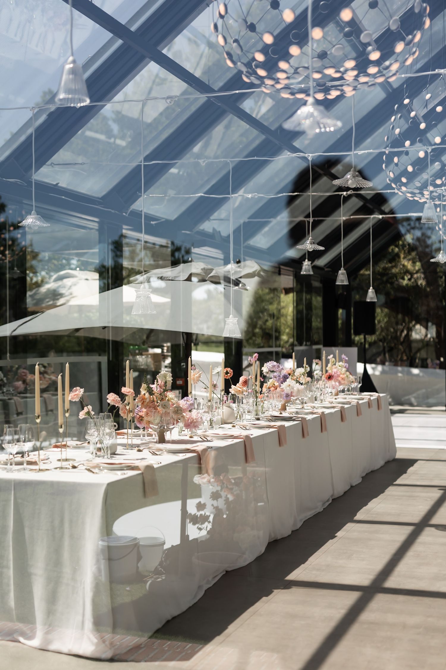 Elegant wedding reception setup under clear marquee with hanging lights and white table settings. - JCclick Wedding photo & Film - Best Cape