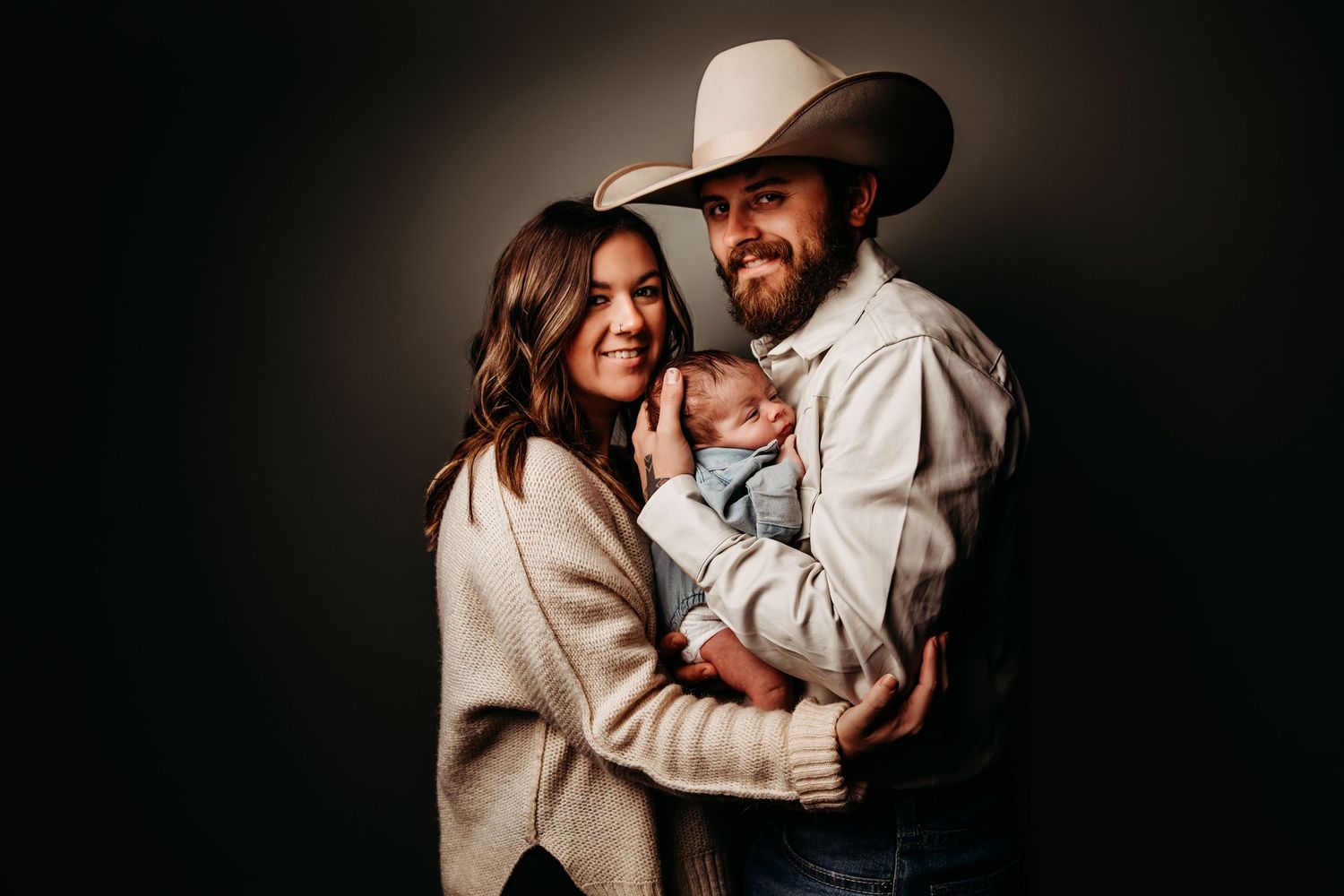 Intimate portrait session with neutral tones against dark studio background.