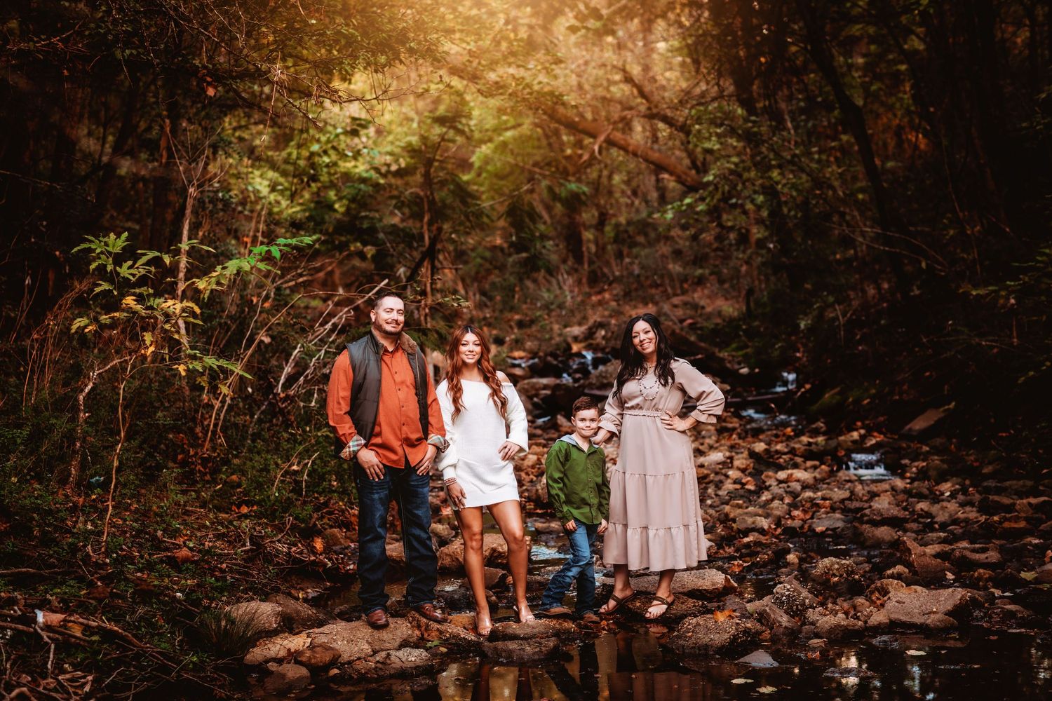 A family walking together on a wooded trail during an autumn afternoon.