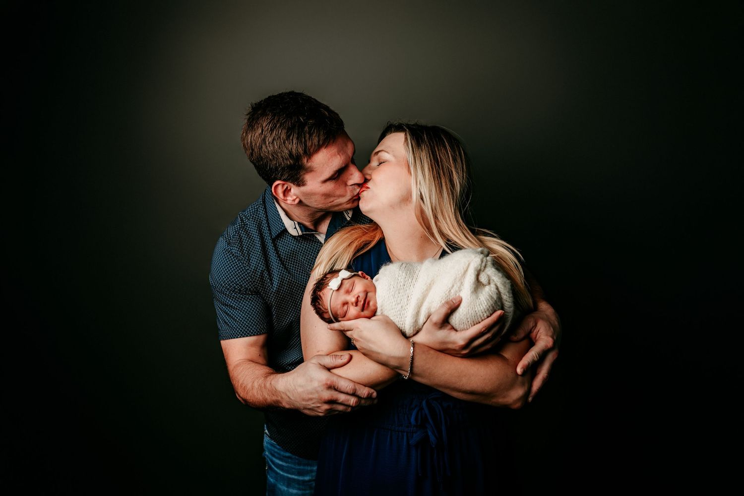 Intimate couple sharing tender moments in a dark moody setting with dramatic lighting and shadows.