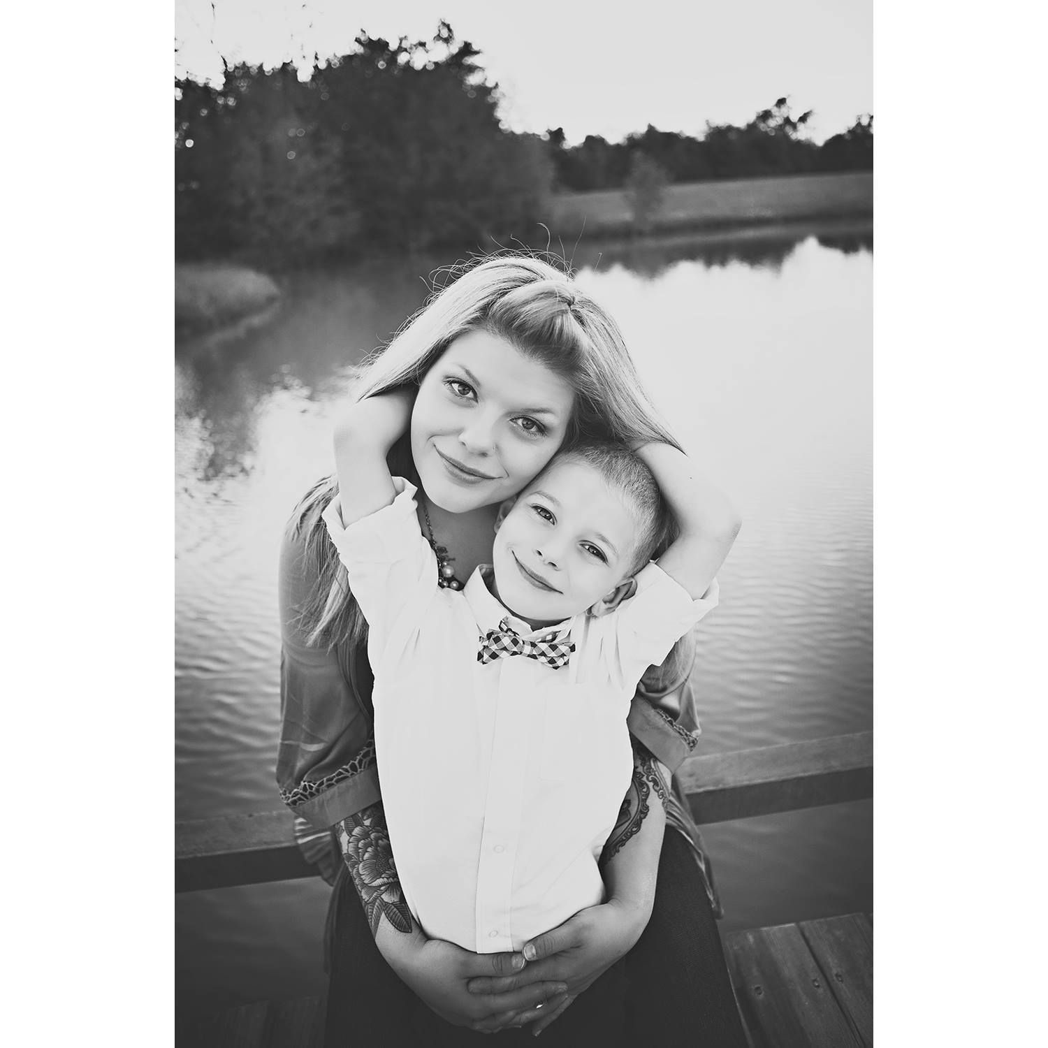 Black and white portrait series of a child outdoors by a lake showing various candid expressions and poses.