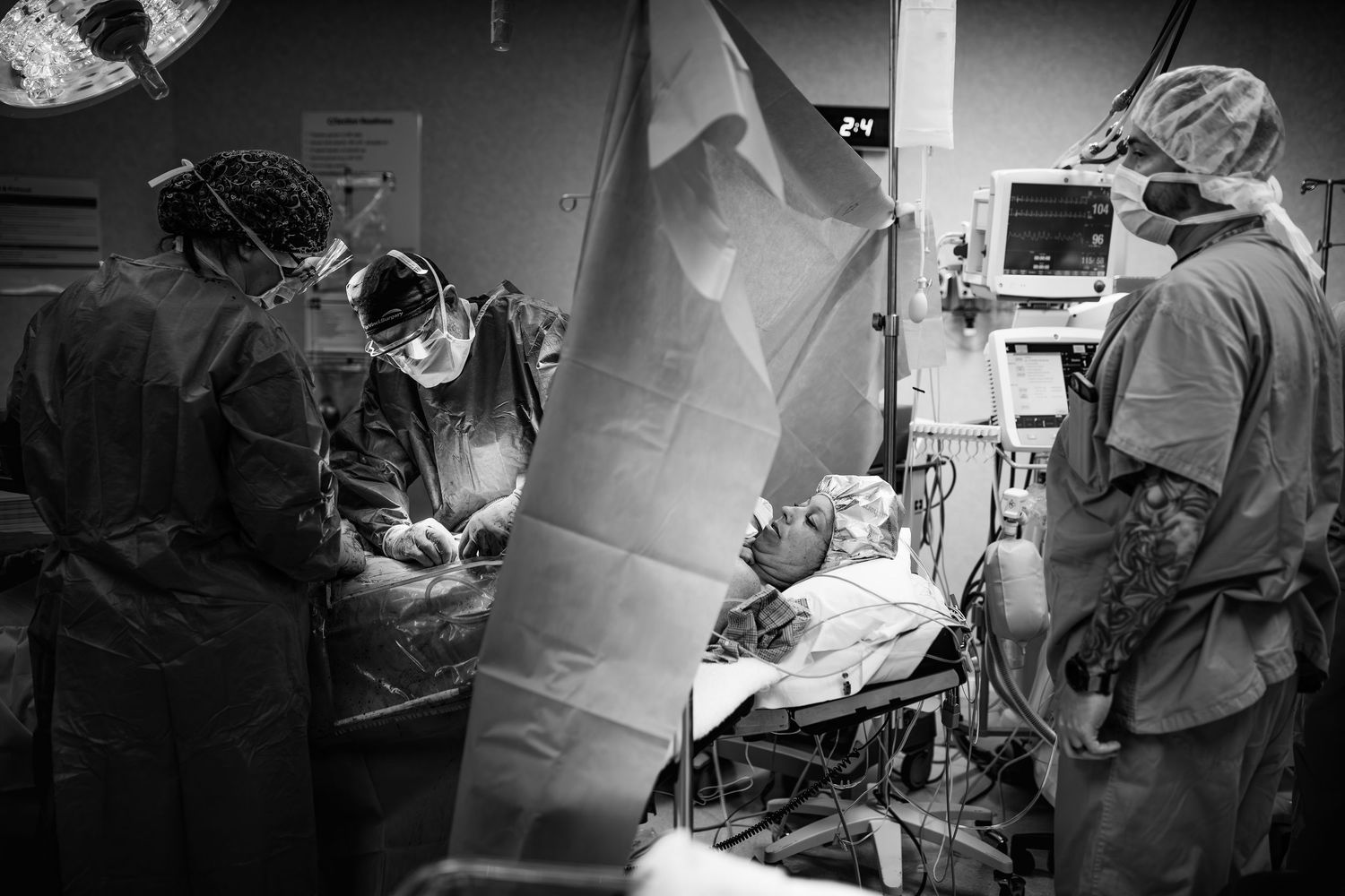 Medical team performs surgery in operating room with specialized equipment and bright lighting.