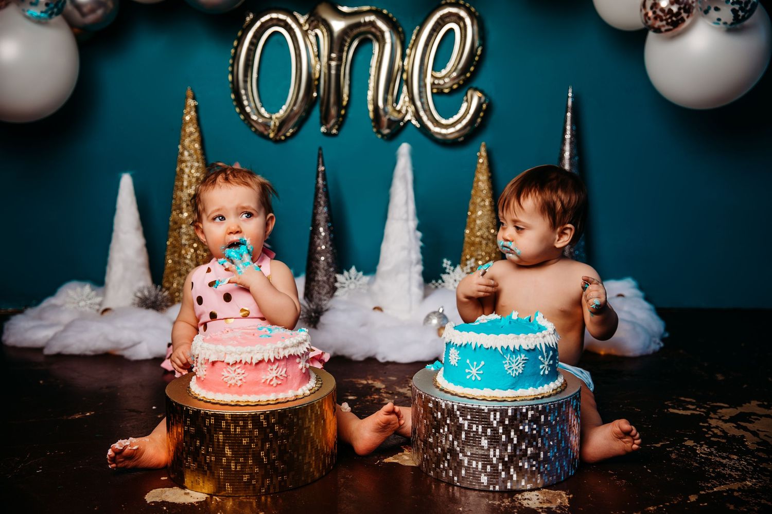 A series of cake smash photos showing a baby's first birthday celebration with pink and blue cakes and decorations.