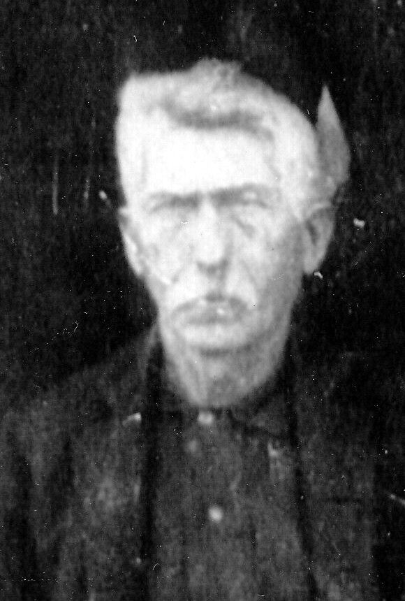 Vintage black and white portrait photo of an elderly man with white hair wearing a dark shirt.