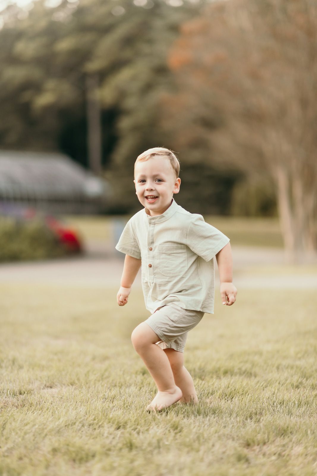 A sequence of images shows a young child in beige clothing running and jumping playfully on grassy terrain outdoors.