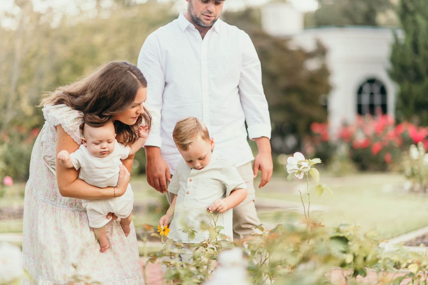 Family members sharing tender moments together in an outdoor garden setting.
