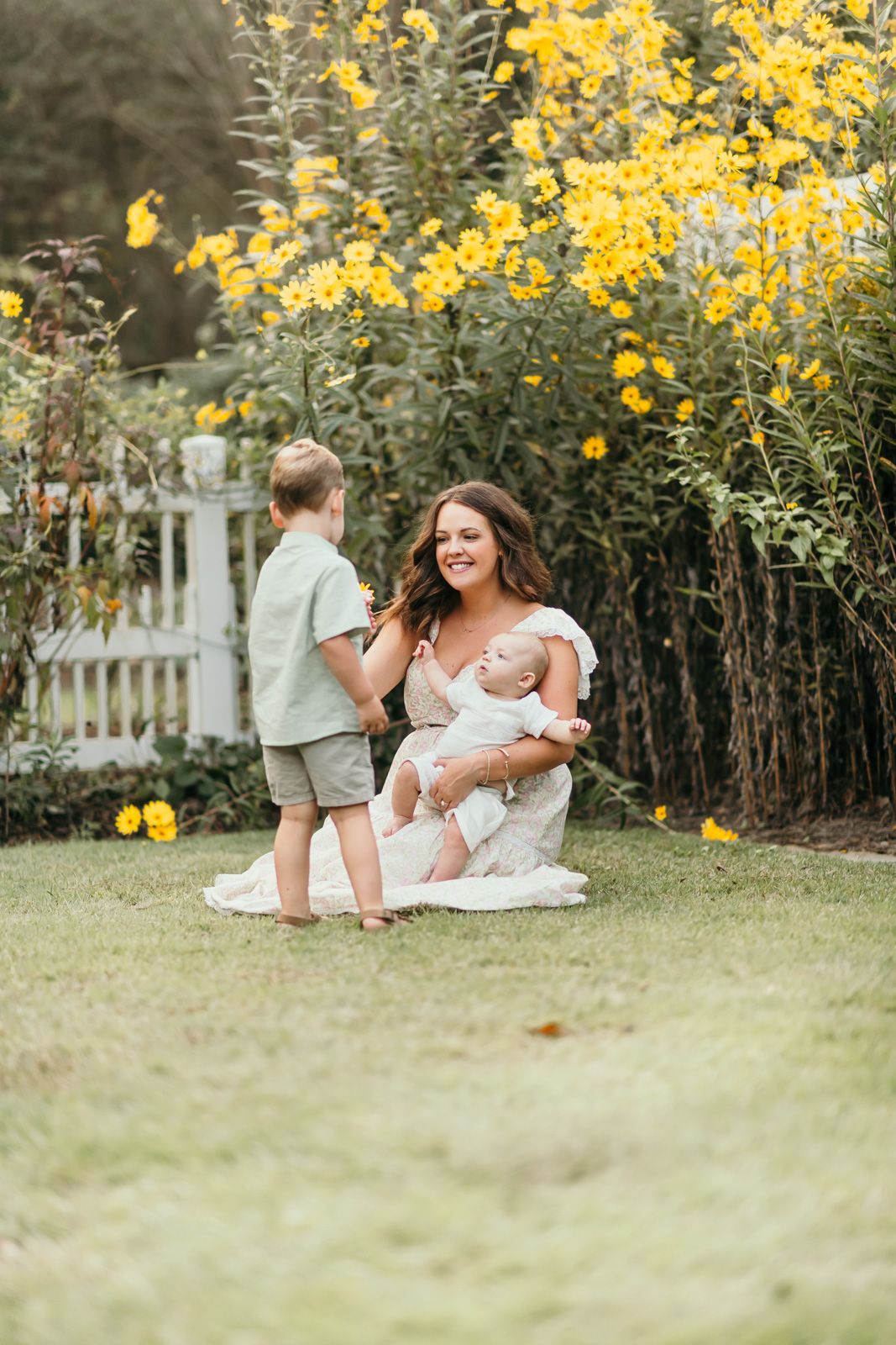 A joyful moment captured in a garden with tall yellow flowers creating a beautiful natural backdrop.