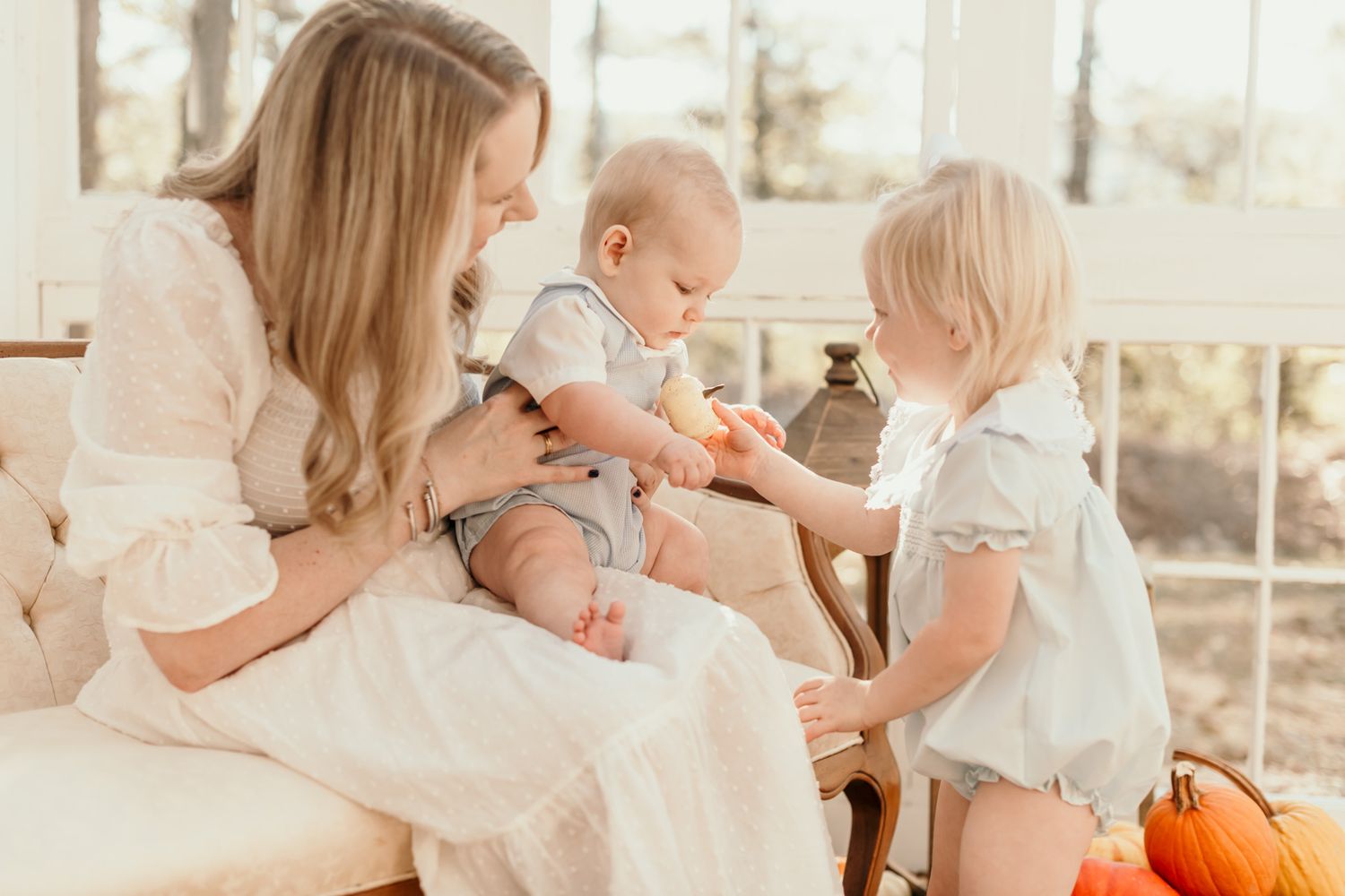 A series of lifestyle photos showing a young child exploring and playing with pumpkins in a cozy indoor setting.