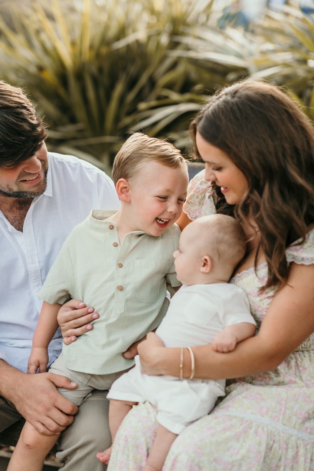 A family shares joyful moments together on a sunny day, laughing and embracing.