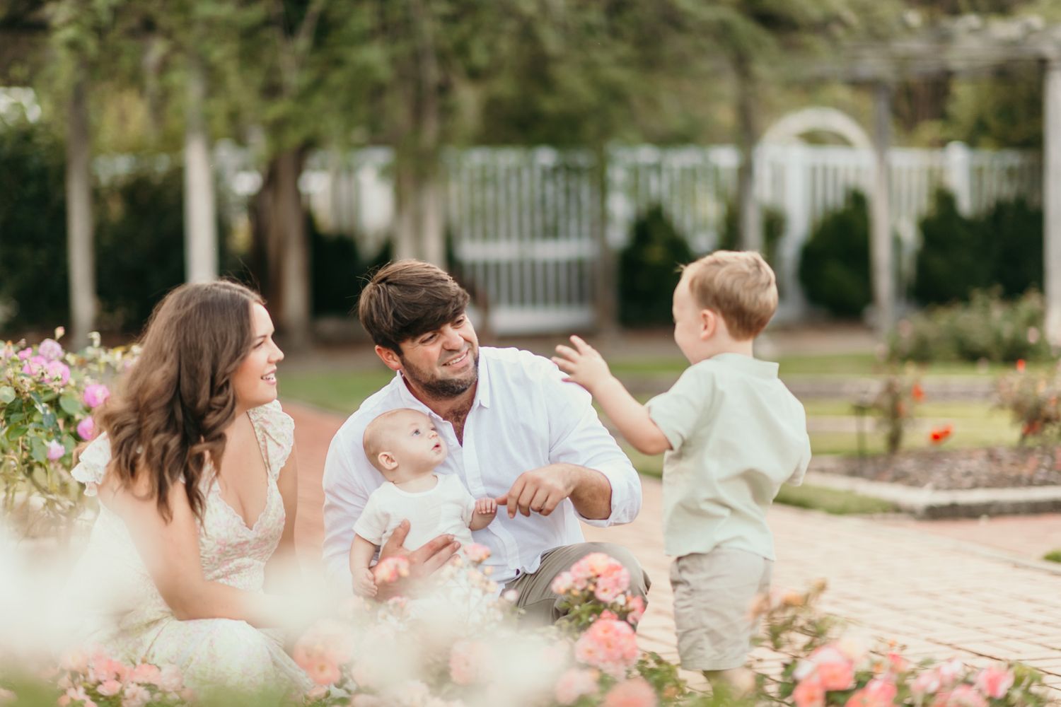 Candid family moments captured on brick pathway during outdoor photo session.