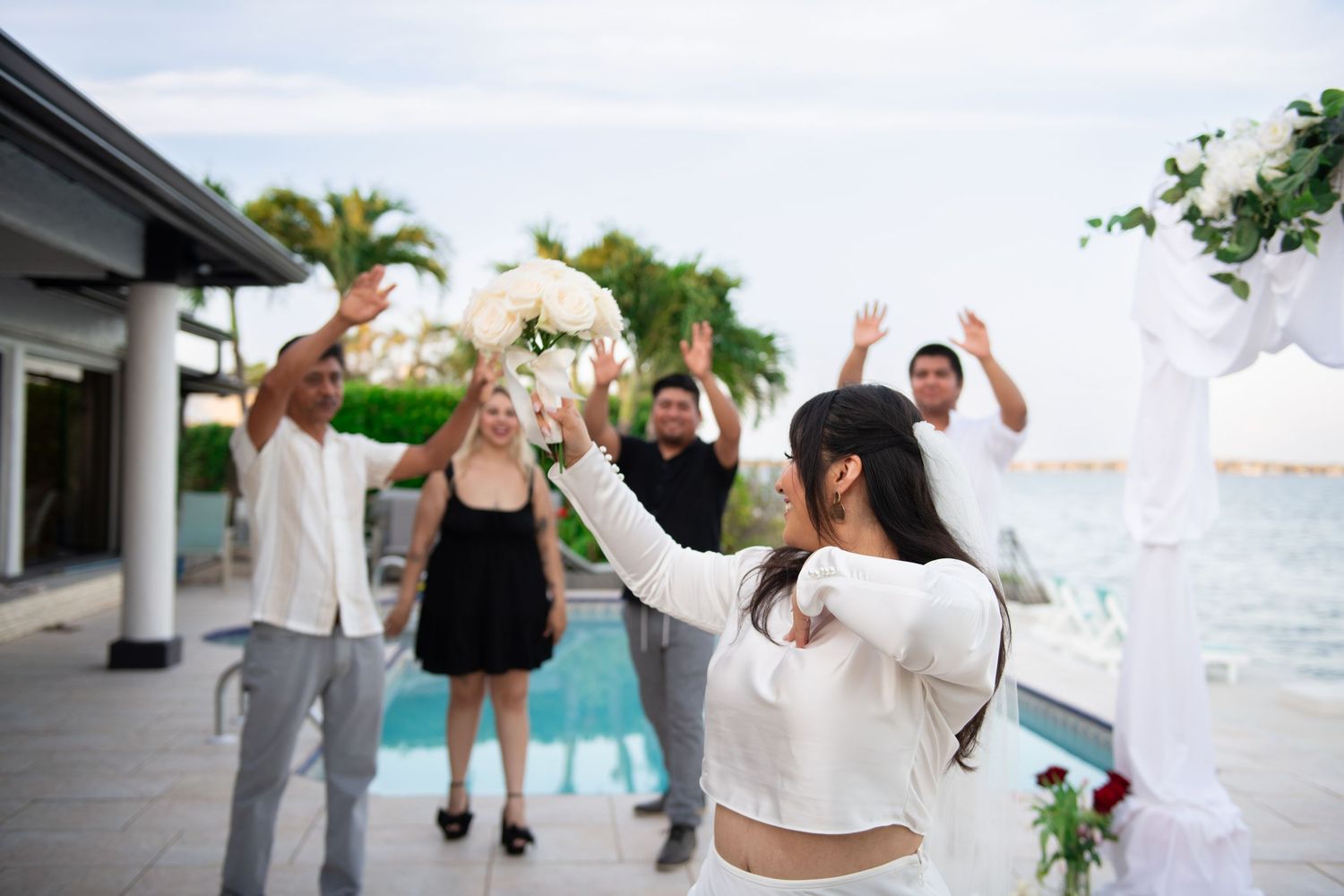 Wedding celebration with guests dancing and celebrating outdoors by the ocean. Wedding photography.