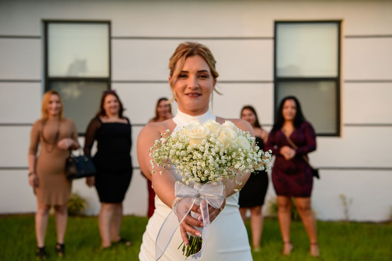 Wedding party gathering outside venue with baby's breath bouquet for wedding photos