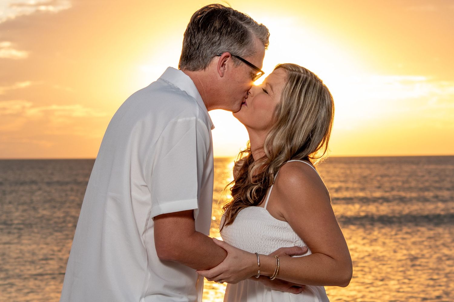 Romantic sunset beach scene with couple sharing intimate moment by ocean. Beach photoshoot. Family photoshoot,