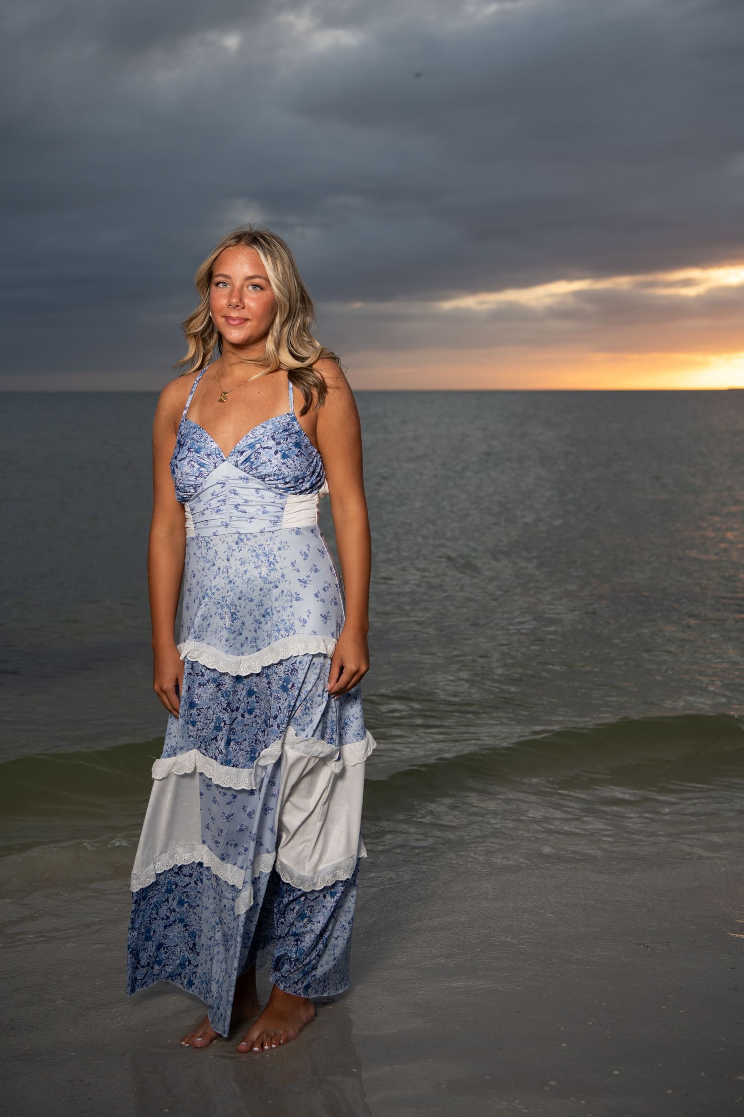 Woman in blue patterned dress posing at beach during sunset. Beach photoshoot. Family photoshoot,