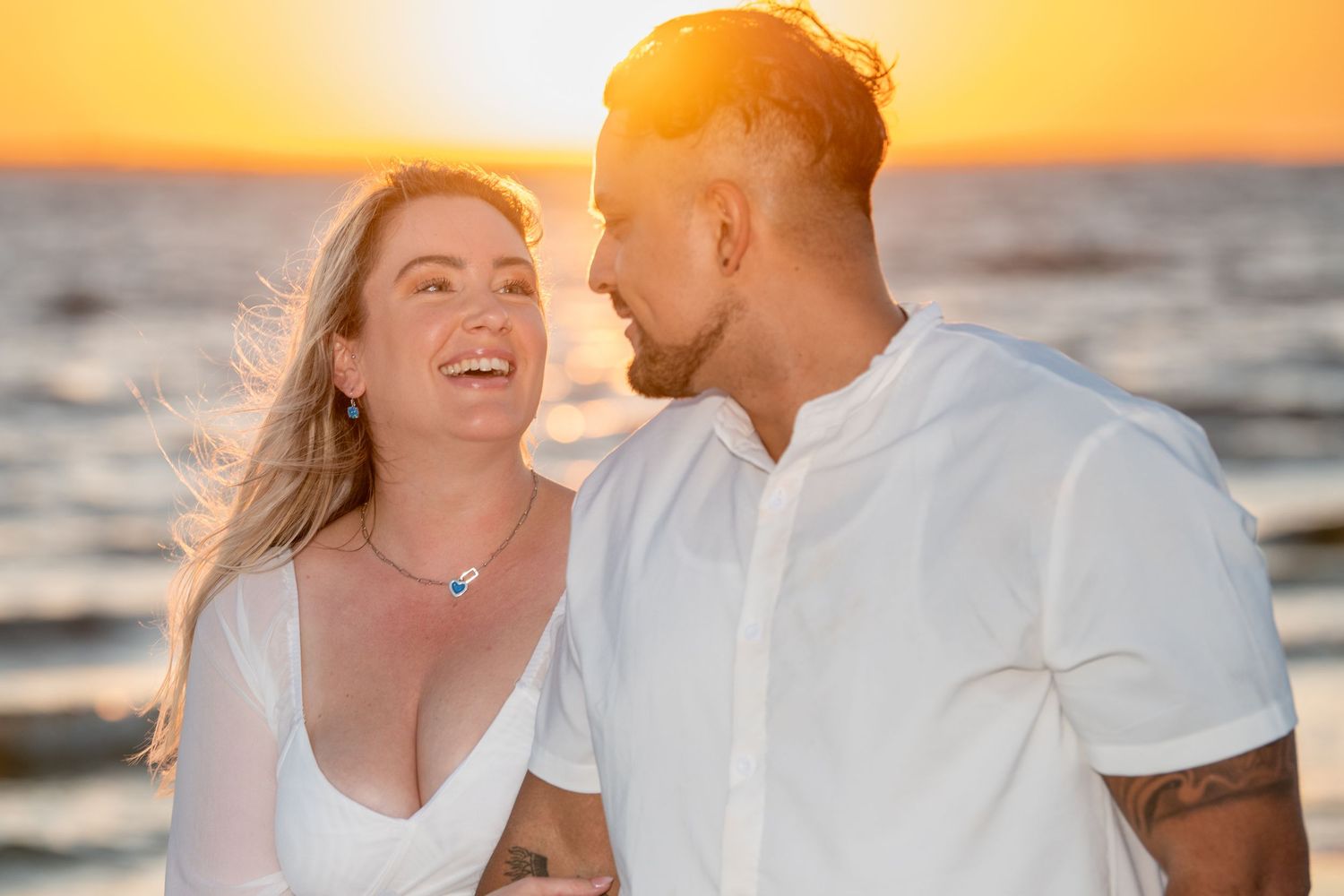 Sunset beach portraits with warm golden lighting and gentle ocean waves.