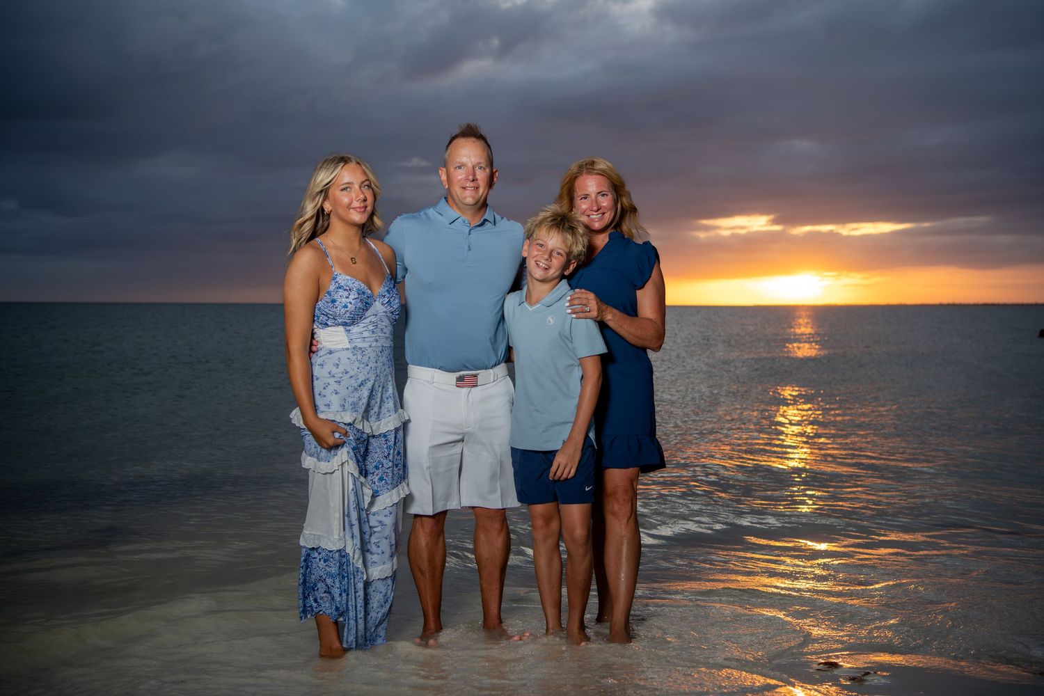 Family group standing together on beach at sunset with ocean view. Beach photoshoot. Family photoshoot,