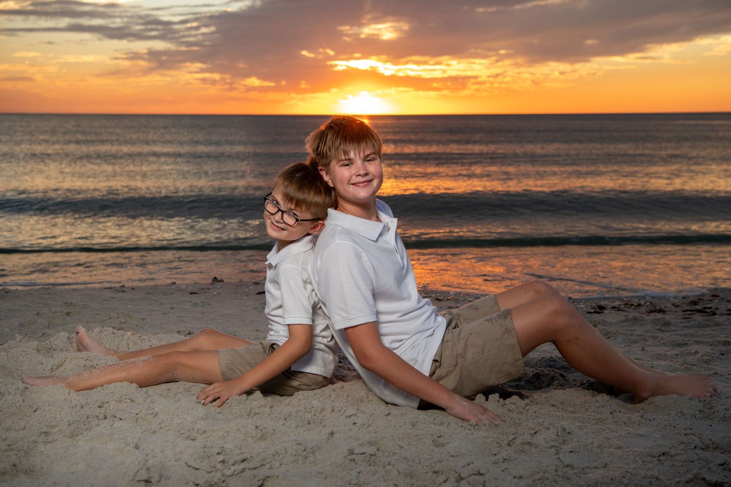 Casual beach portraits with relaxed poses on sand during sunset. Beach photoshoot. Family photoshoot,