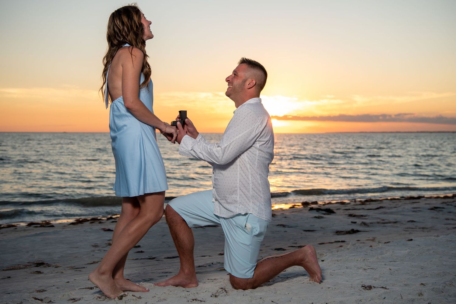 Beach marriage proposal at sunset with ocean waves in background. Engagement photoshoot. Couples photos.