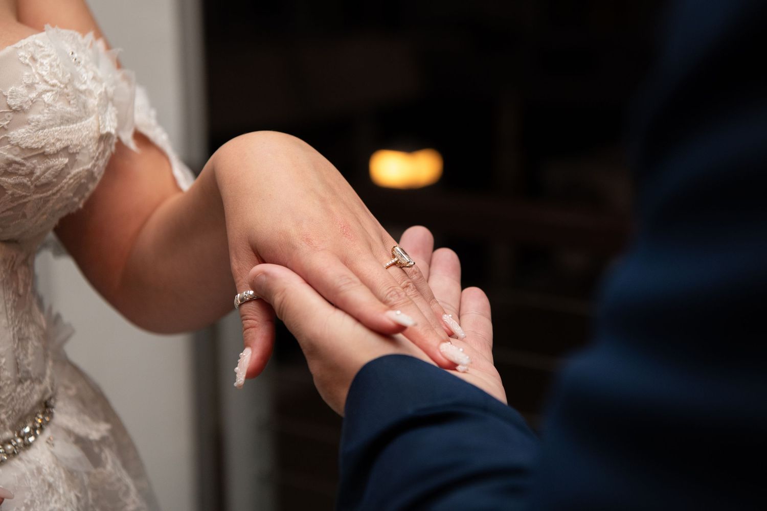 Close-up shot of hands exchanging wedding rings during a ceremony.
