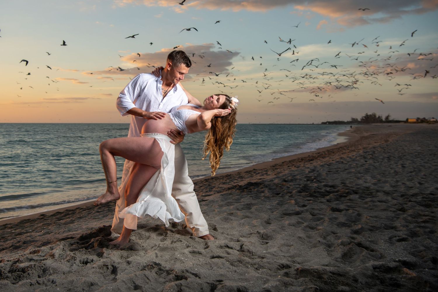 Artistic beach dance photography with seabirds flying at dusk. Maternity photoshoot,
