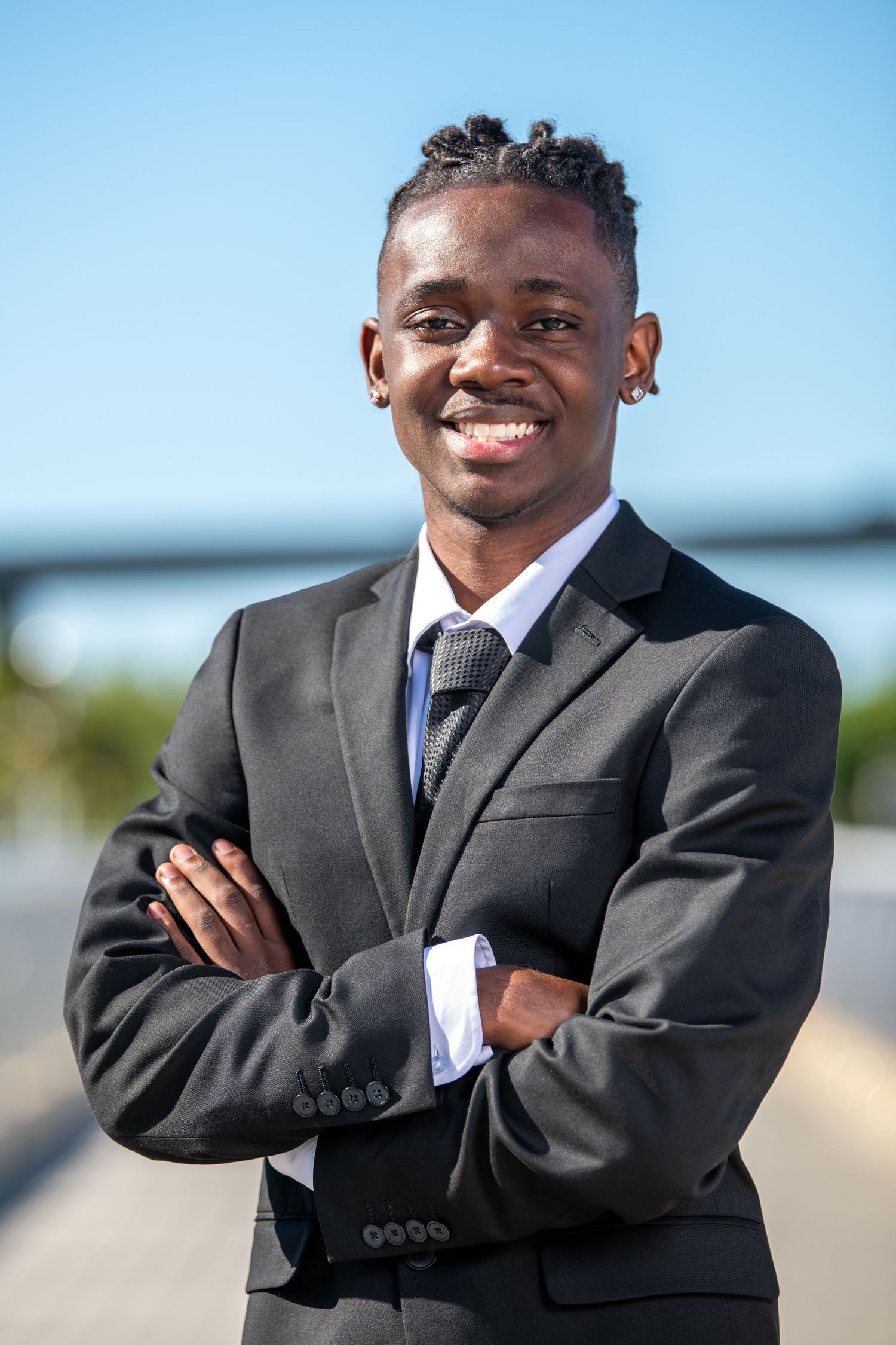 Outdoor portrait series showing a person in a business suit against a bright blue sky. Professional headshots. Self portraits.