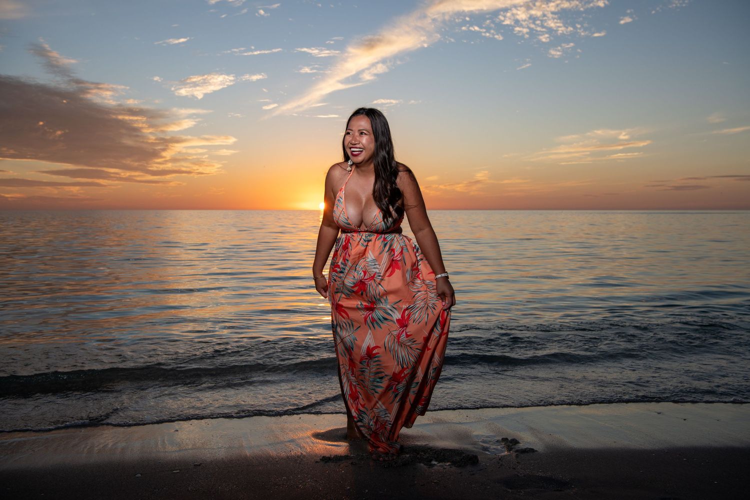 Red floral dress catches wind during beach sunset photoshoot. Beach photoshoot.