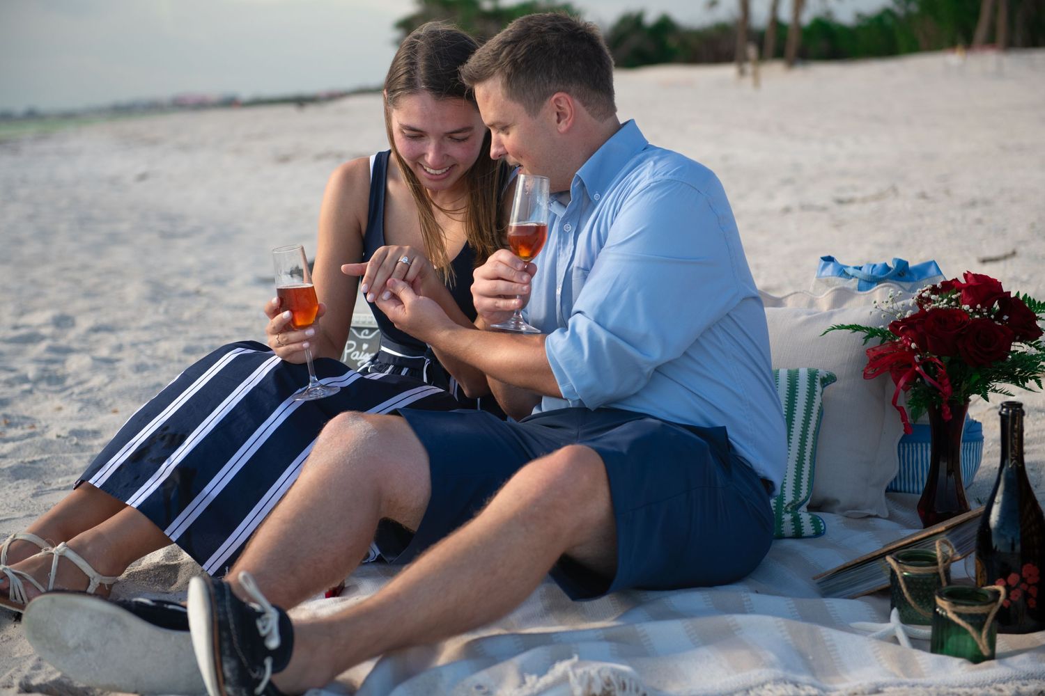 Candid beach engagement moments captured at sunset.