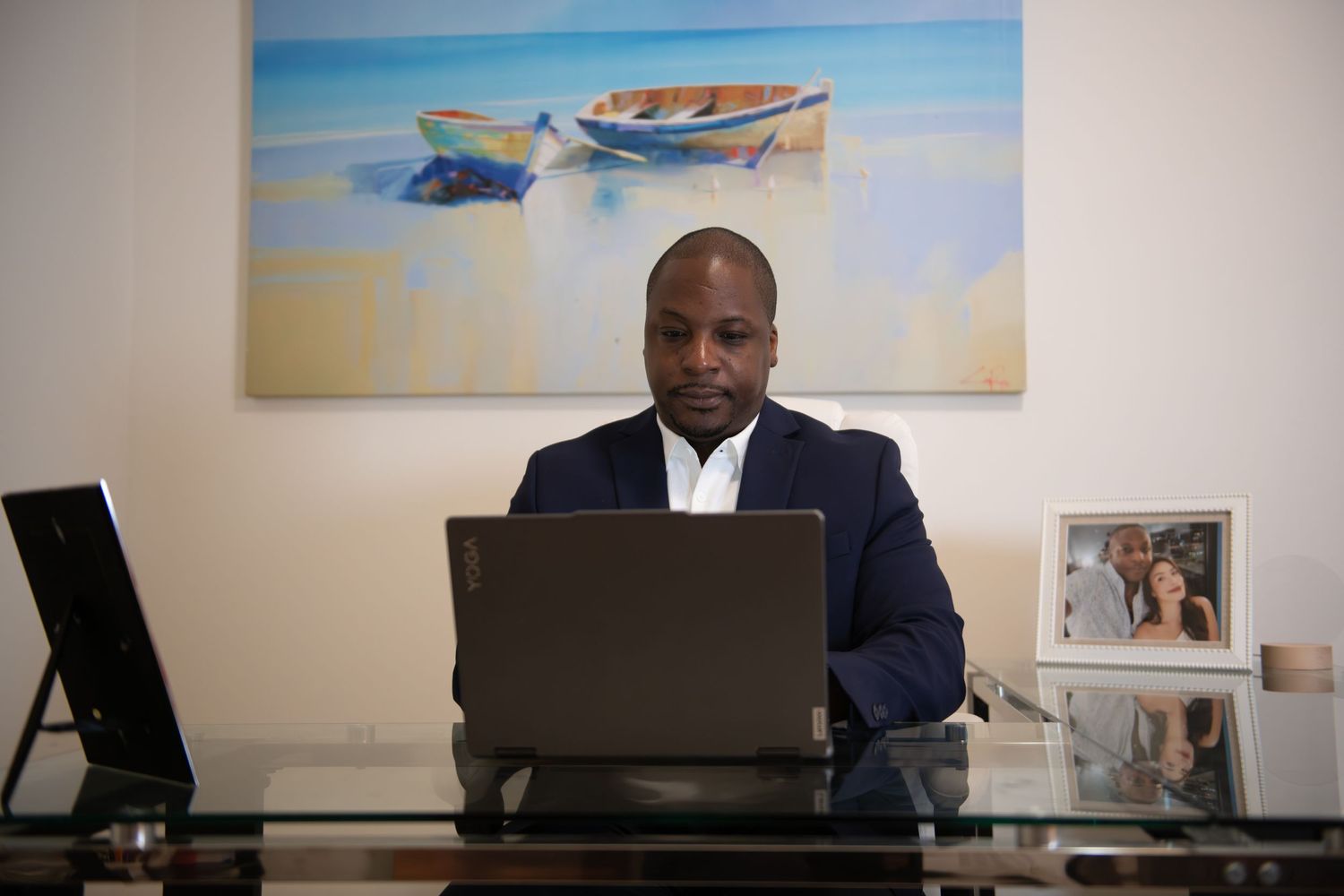 Professional office setting with laptops and wall art featuring beach scenes.