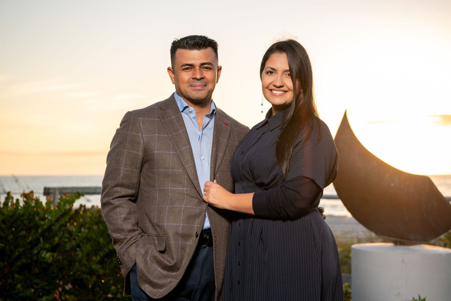 Romantic sunset portraits of a couple in business casual attire outdoors. Family photoshoot.