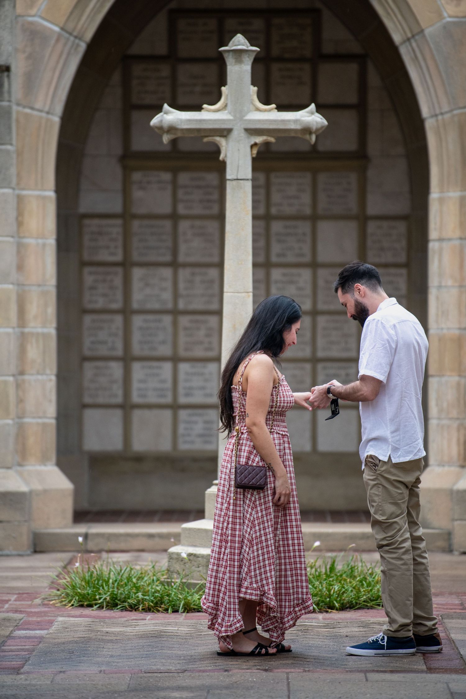 A romantic proposal sequence showing a couple in a historic stone colonnade.