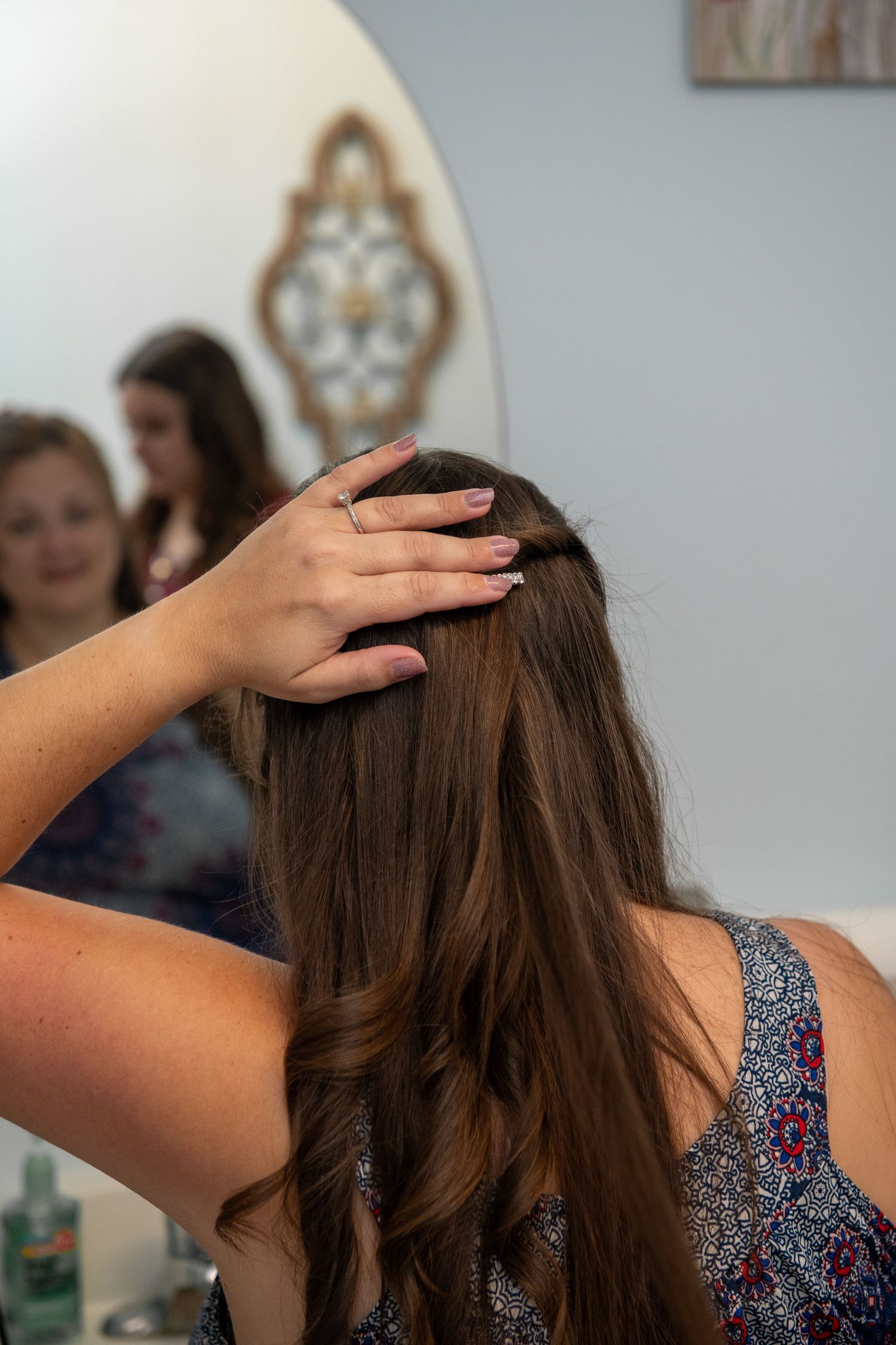 Series showing someone styling long brown hair from behind.