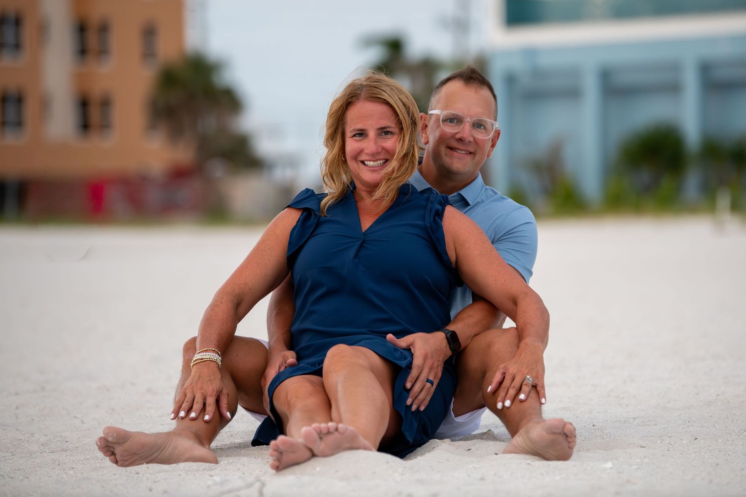 Casual beach portrait session with sand and buildings in background. Beach photoshoot. Family photoshoot,